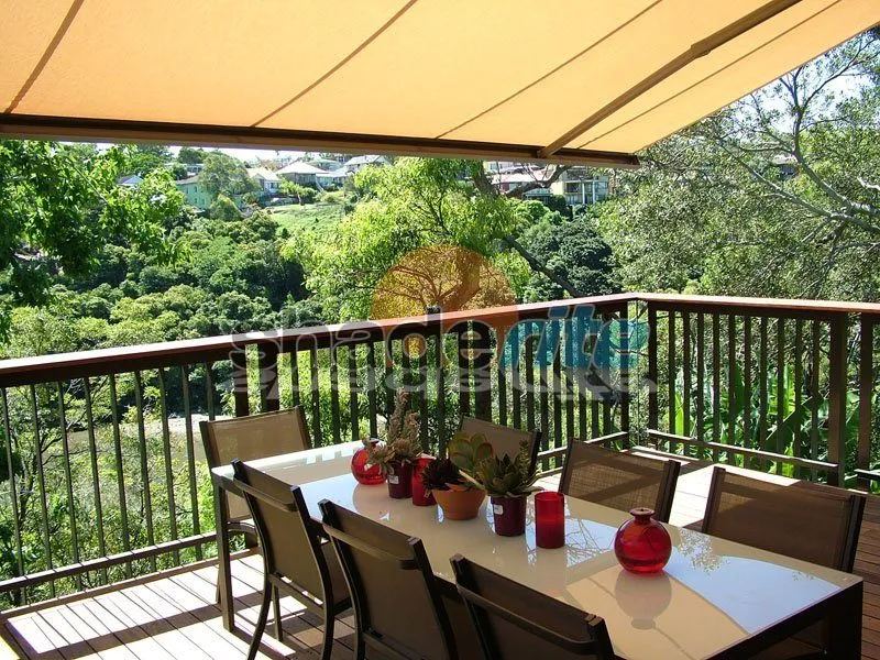 Folding arm awning over an outdoor entertaining area